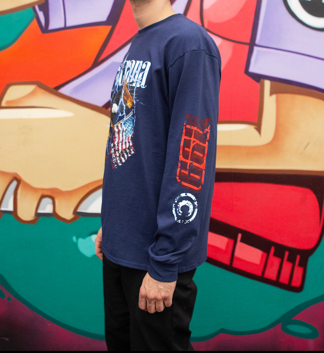 Travis Pastrana FLY HIGH Long Sleeve Tee in navy, featuring a bold graphic design, model wearing it outdoors.