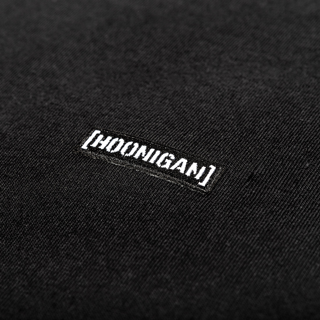 Black Hoonigan STANDARD ISSUE short sleeve tee featuring a bold white logo on the chest, designed for casual wear and automotive enthusiasts.