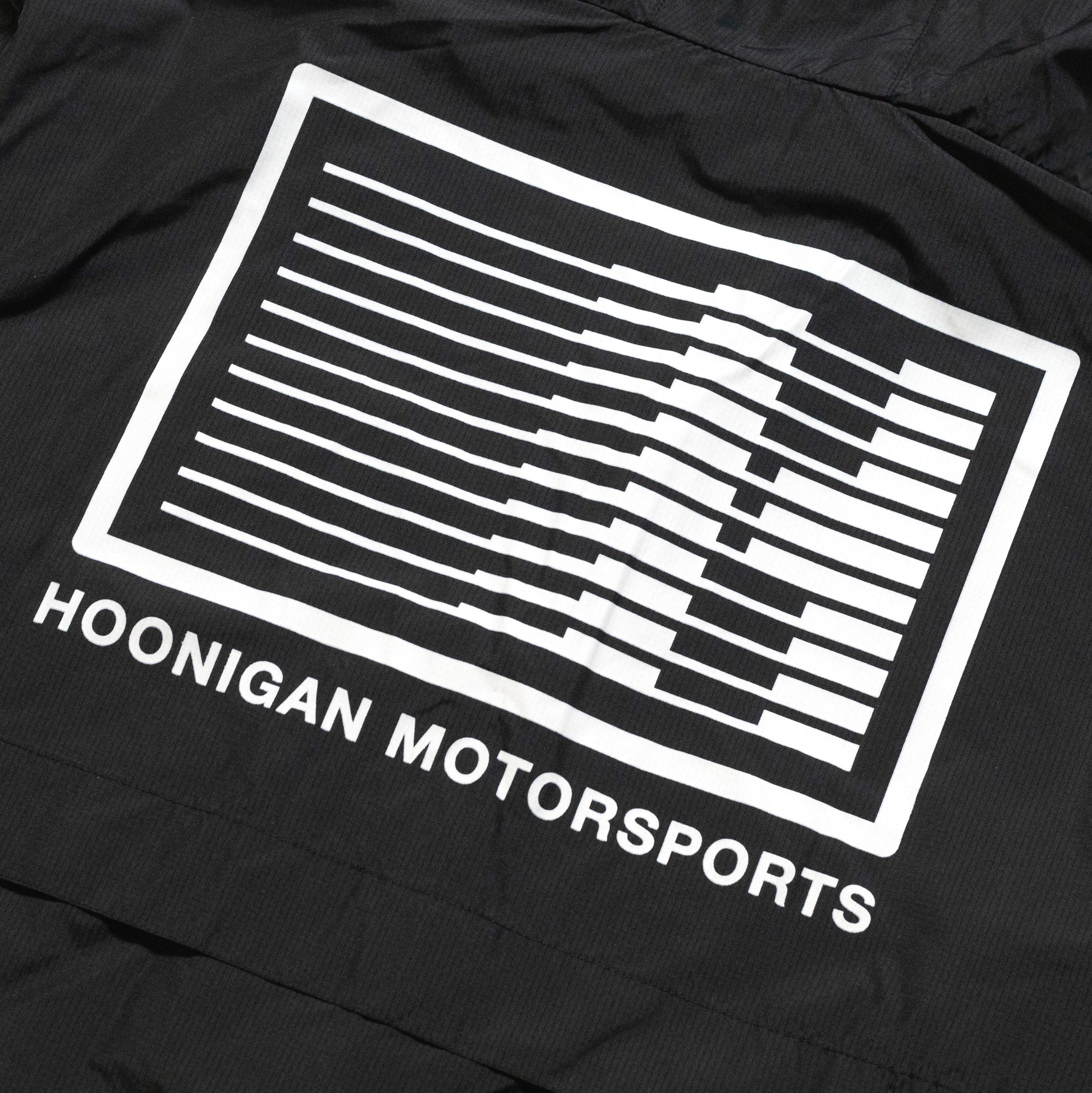 Hoonigan Motorsports Windbreaker Jacket featuring a bold back design with logos and graphics in a stylish black and red color scheme.