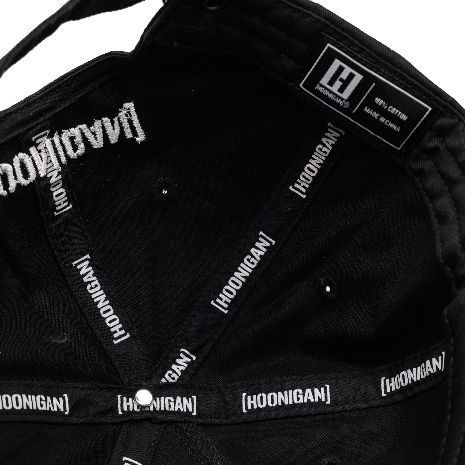 Hoonigan MAYHEM Unstructured Strapback Hat in black, featuring bold white logo embroidery on the front and an adjustable strap at the back.
