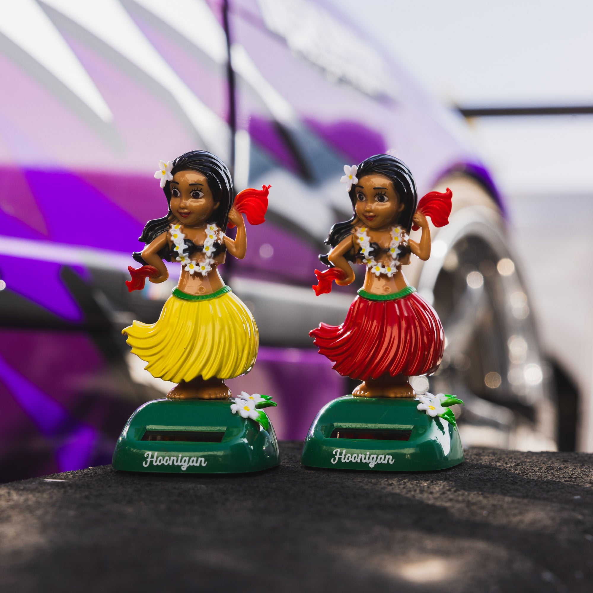 Hoonigan HULAgan GIRL graphic art featuring a female figure in a hula skirt, vibrant colors, and a playful design.