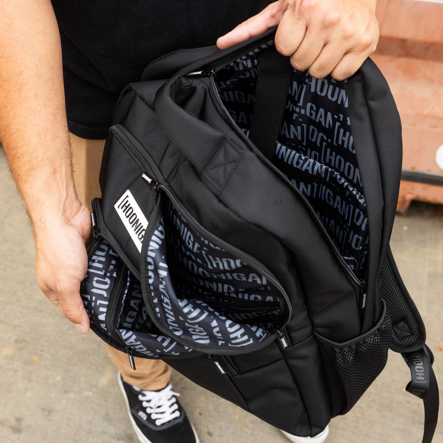 Hoonigan METAL BAR Backpack featuring a sleek design with adjustable straps and multiple compartments in black with logo details.