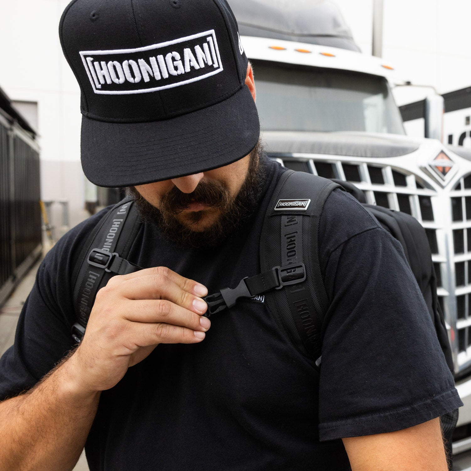 Hoonigan METAL BAR Backpack featuring a bold graphic design, adjustable straps, and multiple pockets for storage.