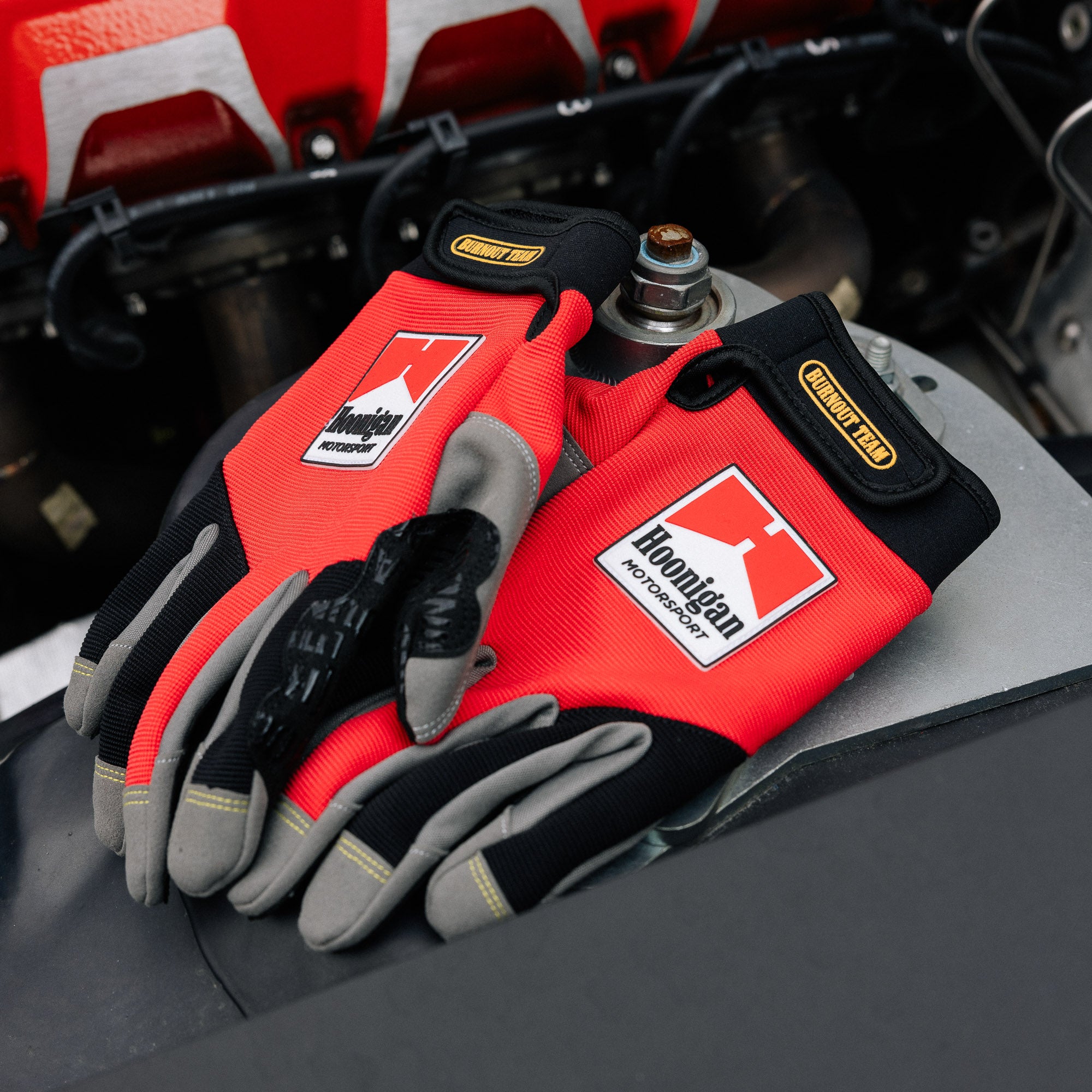 Hoonigan Surgeon General Gloves featuring a sleek black design with bold white graphics and logo.