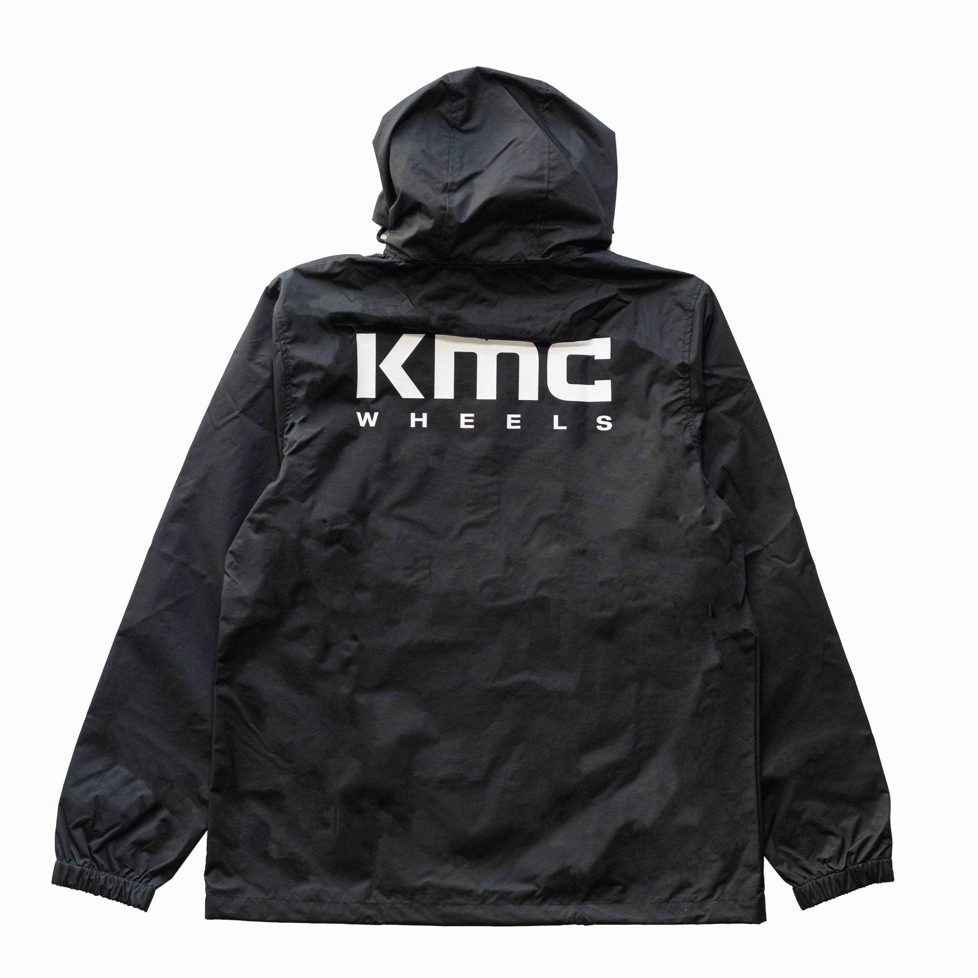 KMC Wheels V2 Half Zip Anorak Jacket in black, featuring a zippered collar, adjustable drawstring hood, and front pocket.