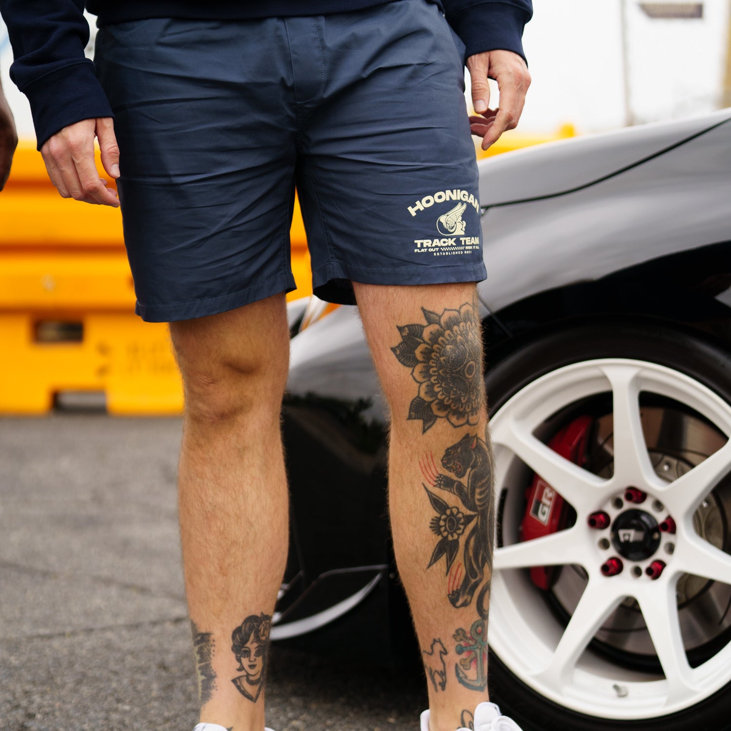 Hoonigan TRACK TEAM Athletic Shorts in black with a logo on the left leg, featuring a drawstring waistband and side pockets.