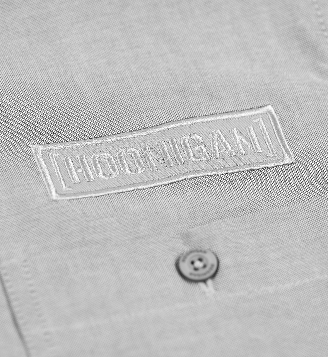 Hoonigan DONUT GARAGE woven long sleeve button-up shirt in heather gray, featuring a button-down collar and a front pocket with logo detail.