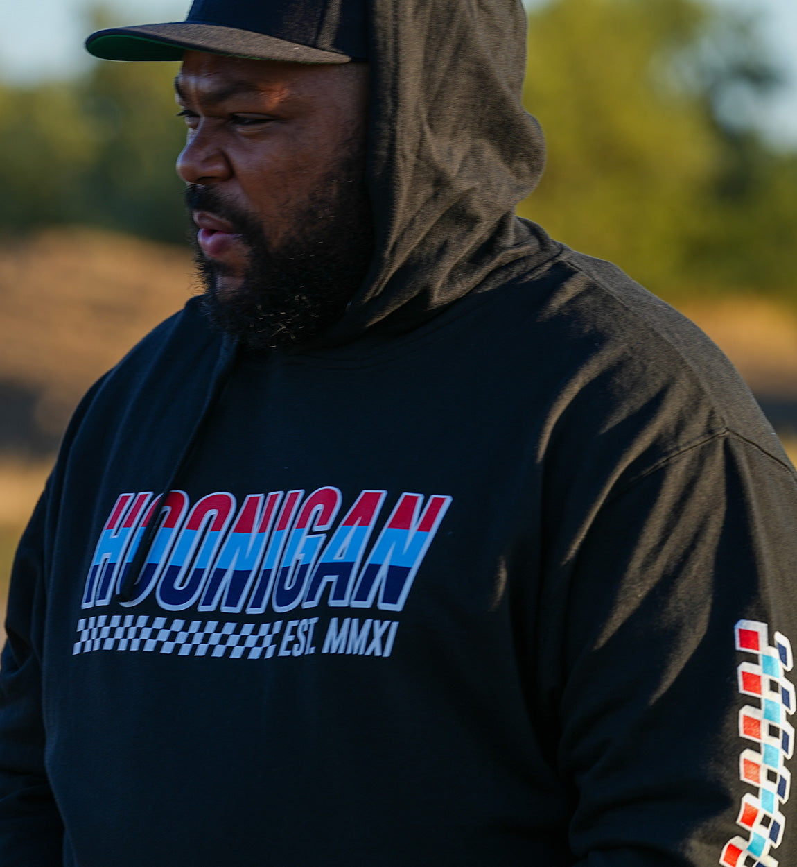 Black DOWNFORCE pullover hoodie with colorful "HOUNGAN" graphic, checkered pattern, and "EST. MMXI" text on front and sleeve.